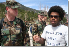 Jarrett talks with a person in the military while wearing a shirt which reads Would You Serve With Me?